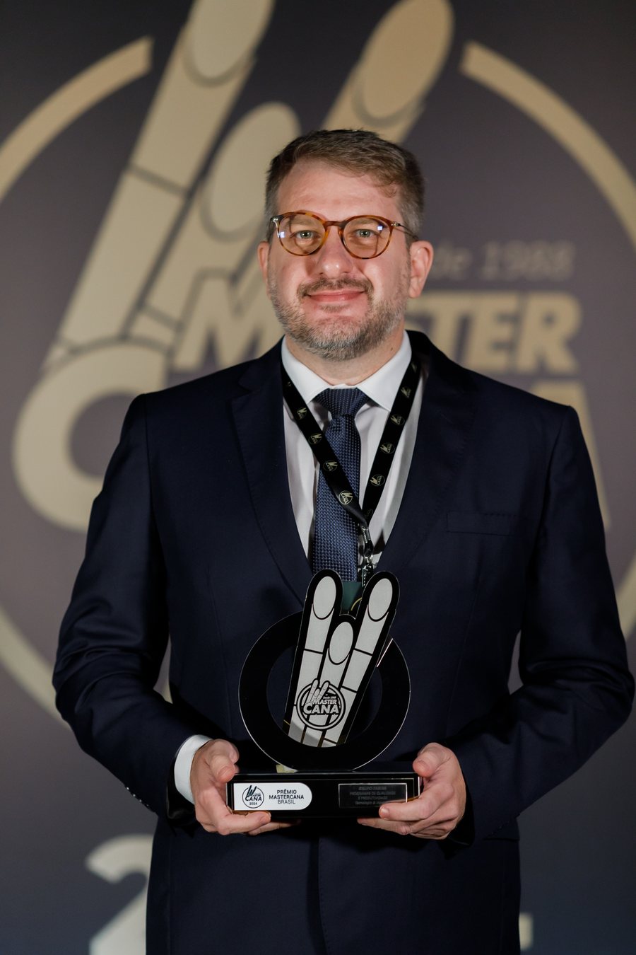 Juliano Braga segurando o troféu do Prêmio MasterCana Brasil 2024